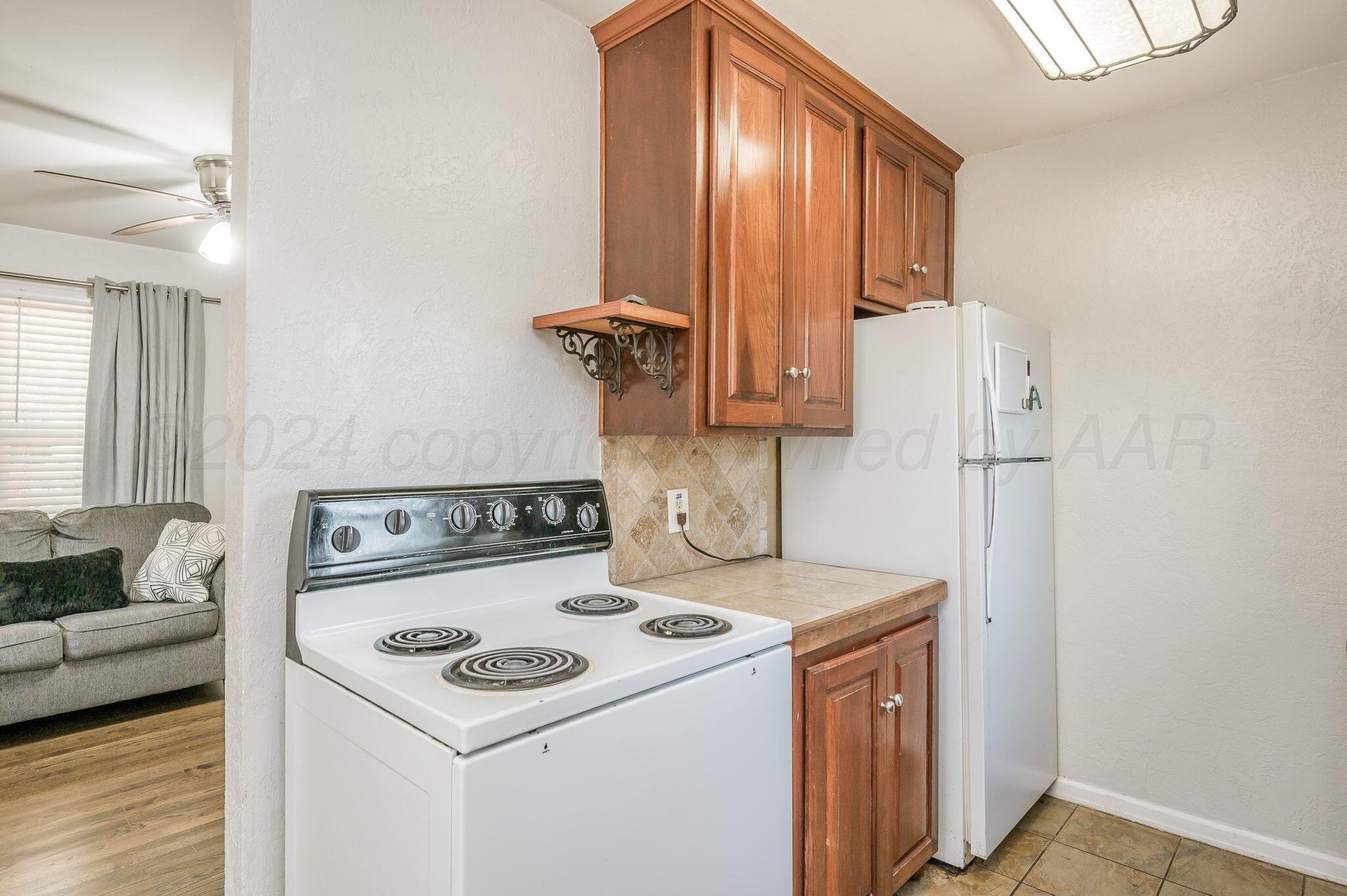 3802 South Jackson Street Amarillo, TX 79110 - Photo 9 of 20 a kitchen with a stove and a refrigerator