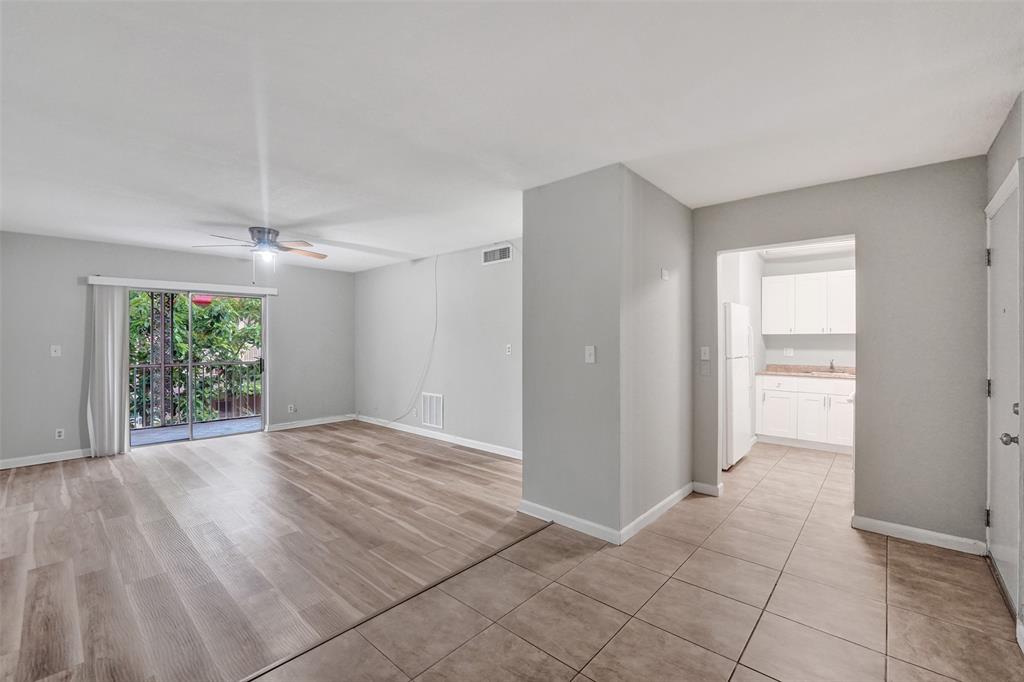 555 Southeast 8th Street, Unit 252 Deerfield Beach, FL 33441 - Photo 13 of 18 a view of an empty room with wooden floor and a window