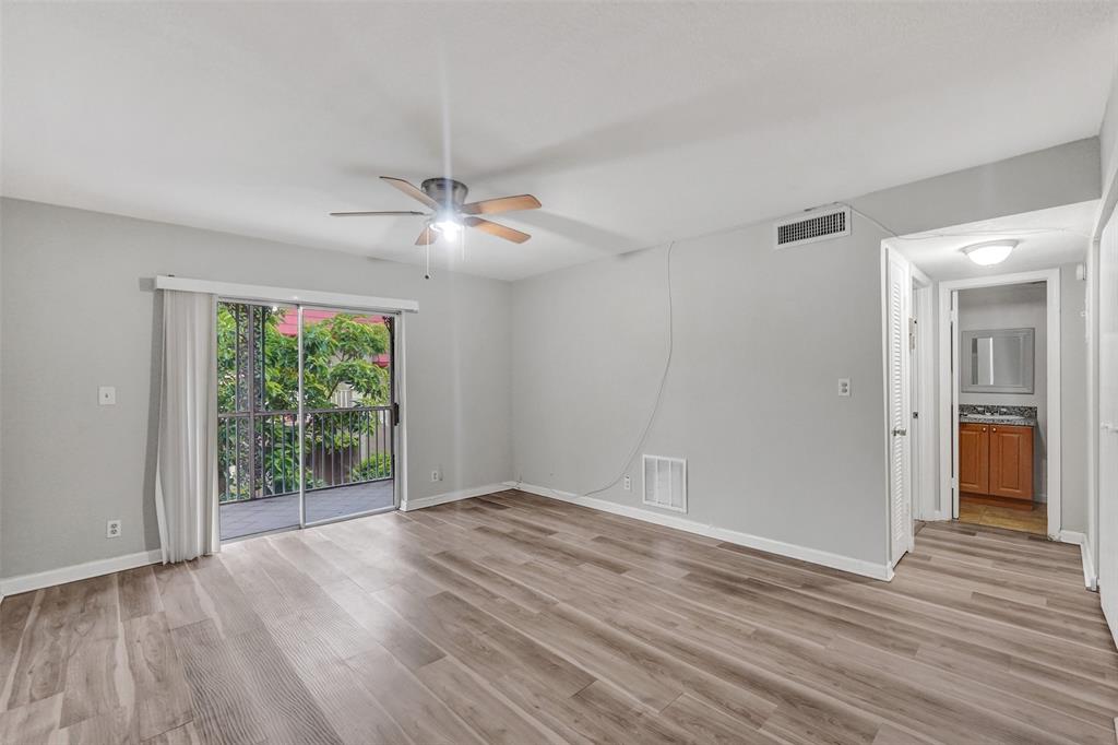 555 Southeast 8th Street, Unit 252 Deerfield Beach, FL 33441 - Photo 16 of 18 a view of an empty room with wooden floor and a window