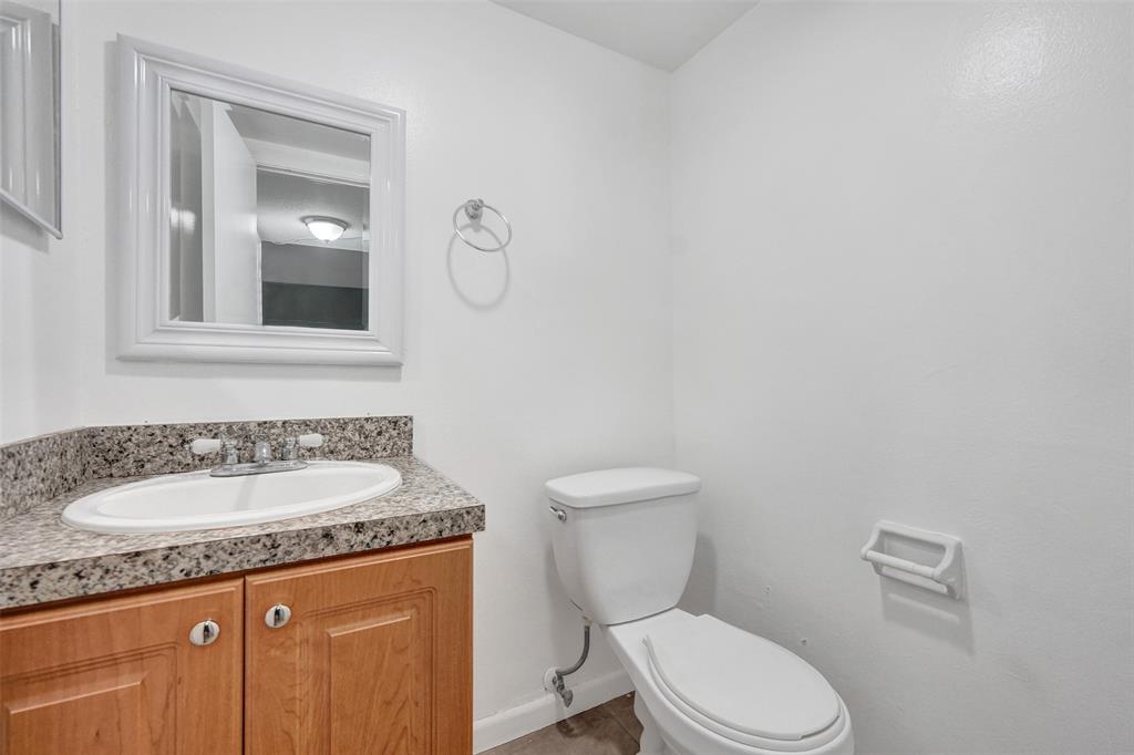 555 Southeast 8th Street, Unit 252 Deerfield Beach, FL 33441 - Photo 17 of 18 a bathroom with a granite countertop toilet sink and mirror