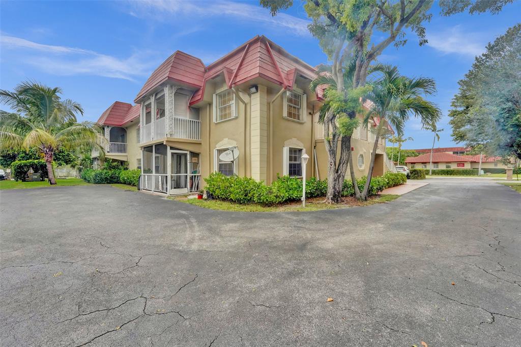 555 Southeast 8th Street, Unit 252 Deerfield Beach, FL 33441 - Photo 18 of 18 a view of a white house with a big yard and potted plants
