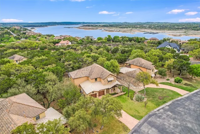 an aerial view of residential houses with outdoor space and ocean view