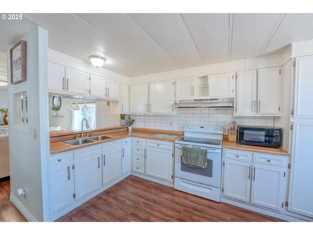 a kitchen with granite countertop white cabinets and white appliances