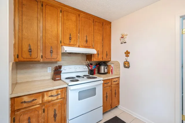 a kitchen with stainless steel appliances white cabinets and a stove top oven