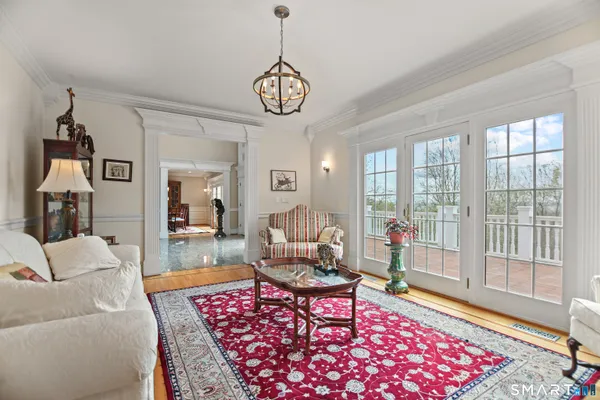 a living room with furniture a rug and a floor to ceiling window
