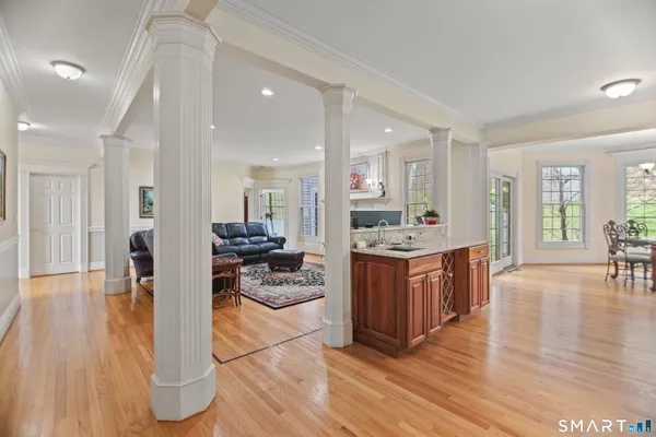 a kitchen with stainless steel appliances kitchen island granite countertop wooden floors and view living room