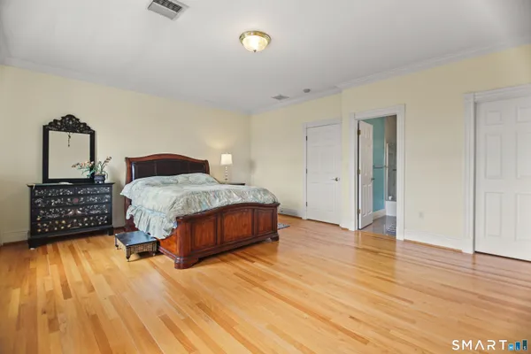 a bedroom with a bed and wooden floor