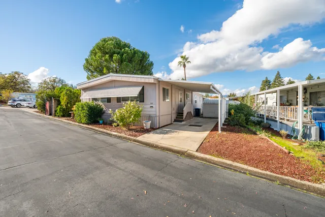 front view of a house with a yard and potted plants