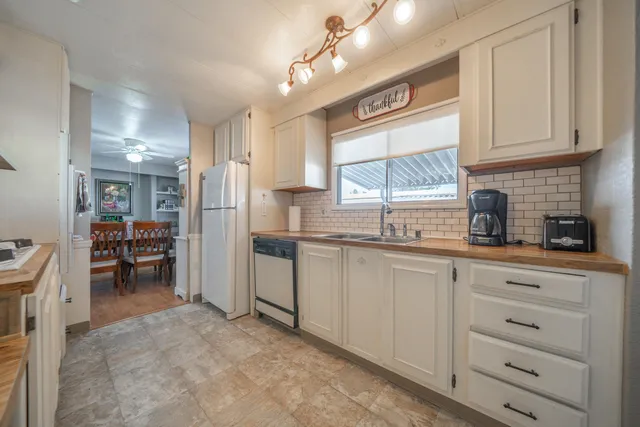 a kitchen with a refrigerator a sink and cabinets