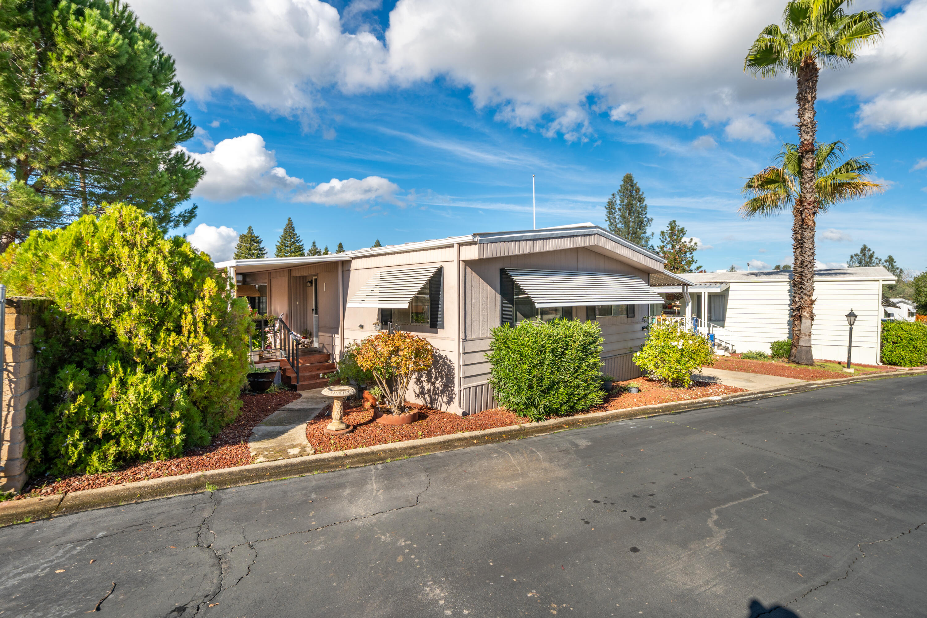 362 Lemon Drive, Unit 24 Redding, CA 96003 - Photo 3 of 44 a front view of a house with a yard and potted plants
