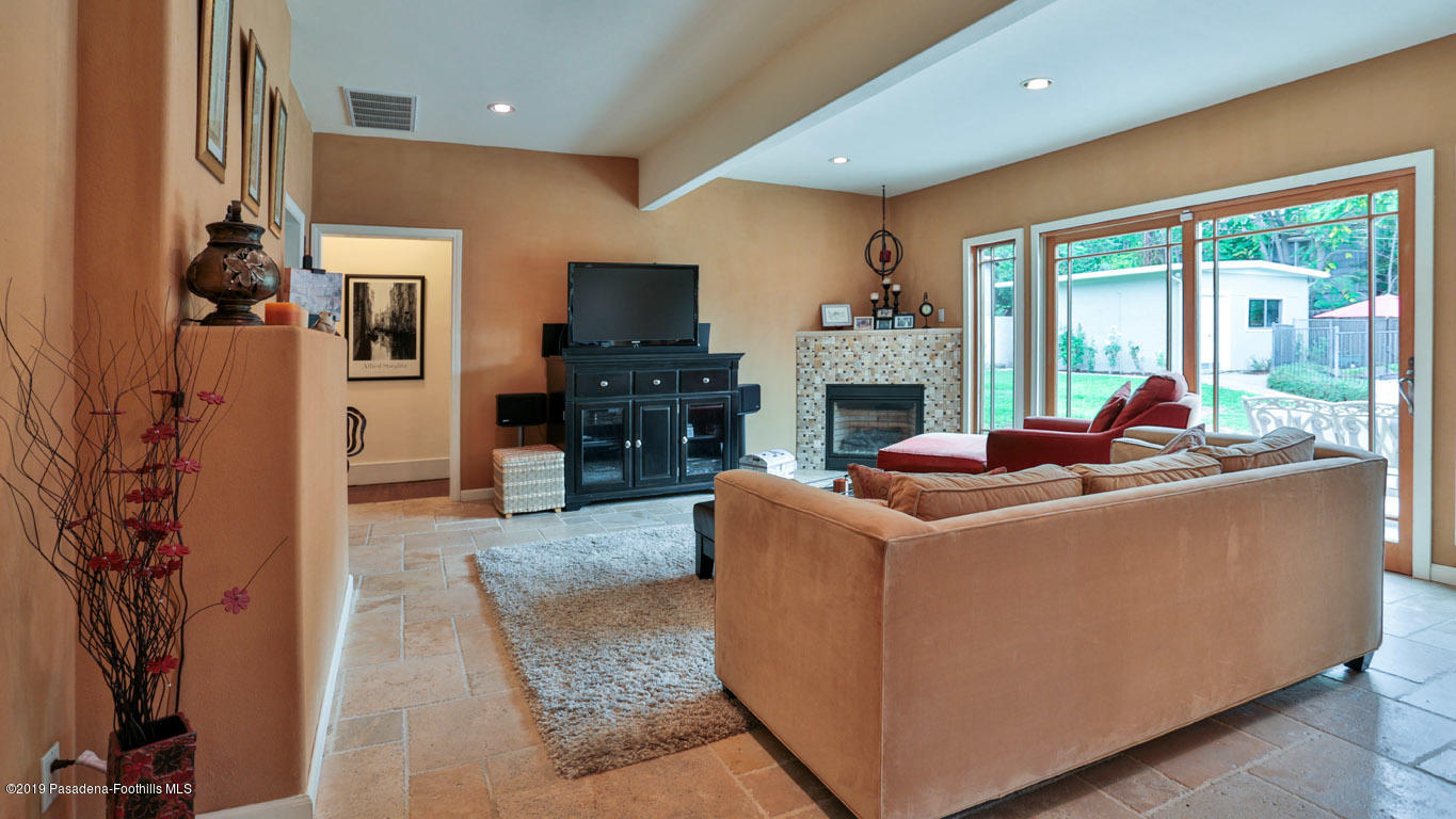 2556 Tanoble Drive Altadena, CA 91001 - Photo 12 of 44 a living room with furniture a flat screen tv and a fireplace