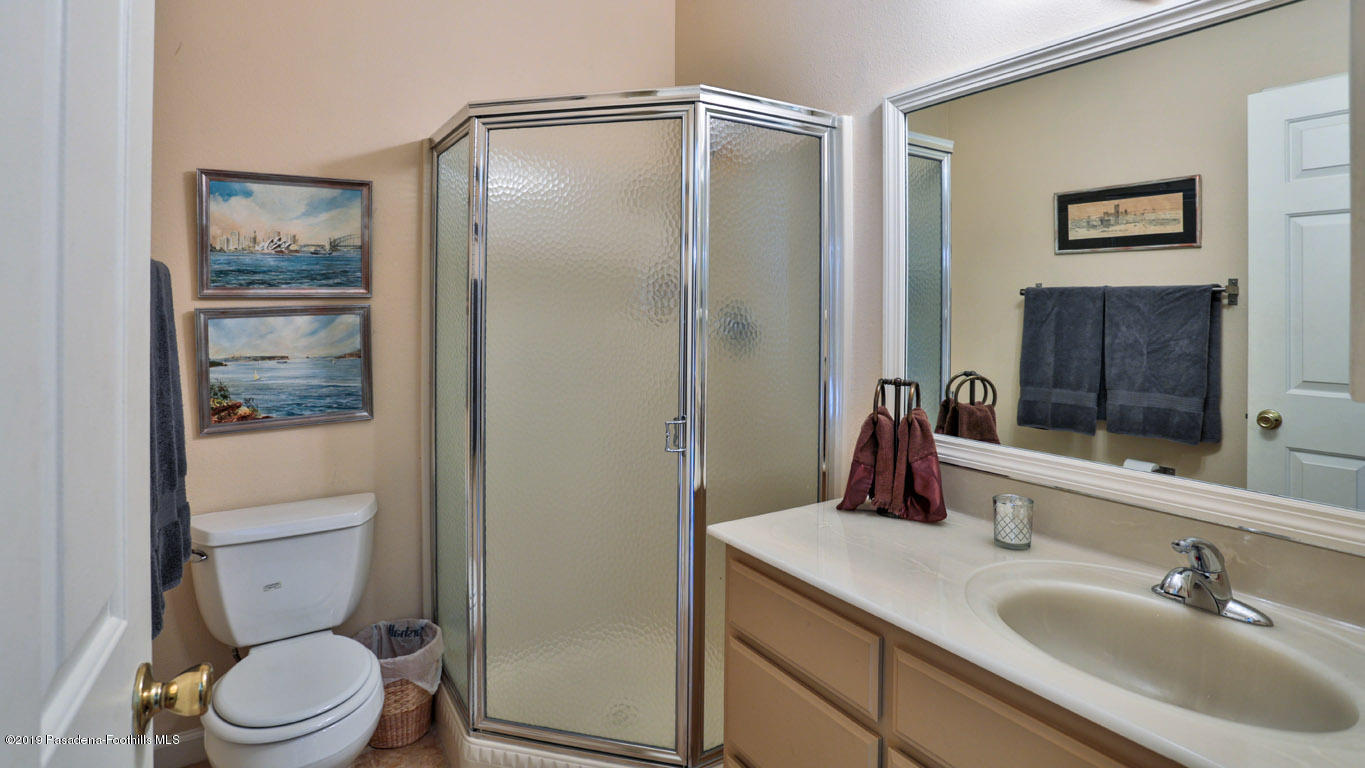2556 Tanoble Drive Altadena, CA 91001 - Photo 17 of 44 a bathroom with a toilet a sink and glass door