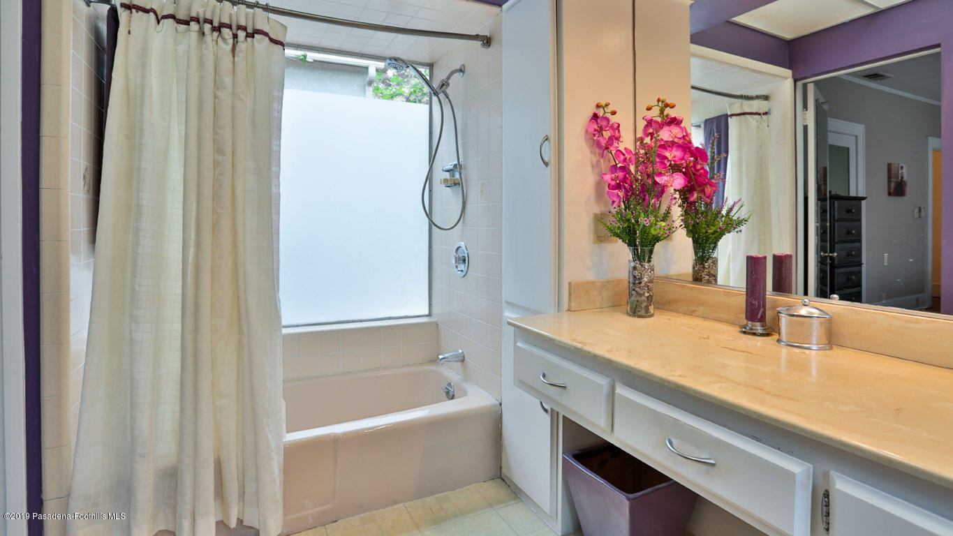 2556 Tanoble Drive Altadena, CA 91001 - Photo 21 of 44 a bathroom with a granite countertop shower a sink and a mirror