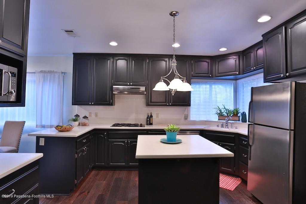 2556 Tanoble Drive Altadena, CA 91001 - Photo 9 of 44 a kitchen with stainless steel appliances kitchen island granite countertop a sink refrigerator and cabinets