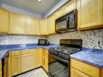 a kitchen with stainless steel appliances granite countertop a stove a sink and a microwave