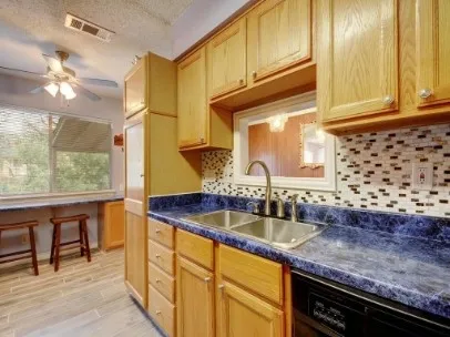 a kitchen with granite countertop a sink a stove and cabinets