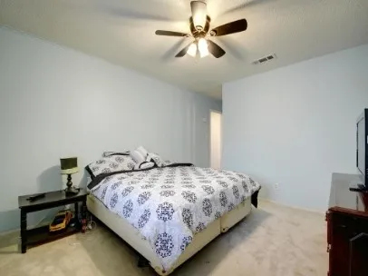 a bedroom with a bed and a ceiling fan