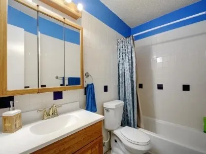 a bathroom with a sink a toilet a mirror and shower