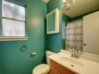 a bathroom with a toilet sink and mirror