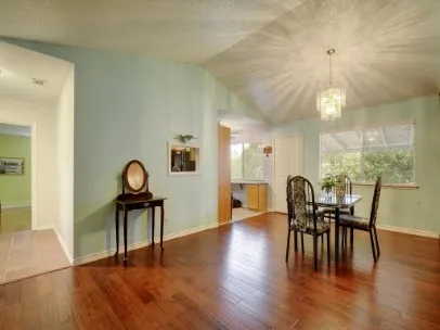 a dining room with furniture a chandelier and wooden floor