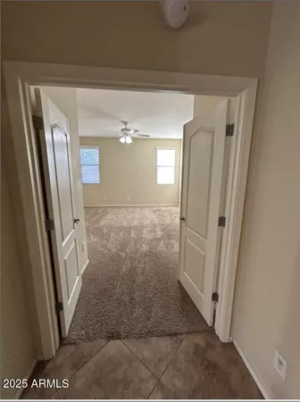 an empty room with chandelier fan