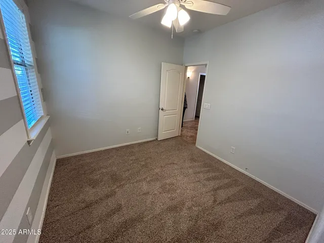 an empty room with fan and entrance