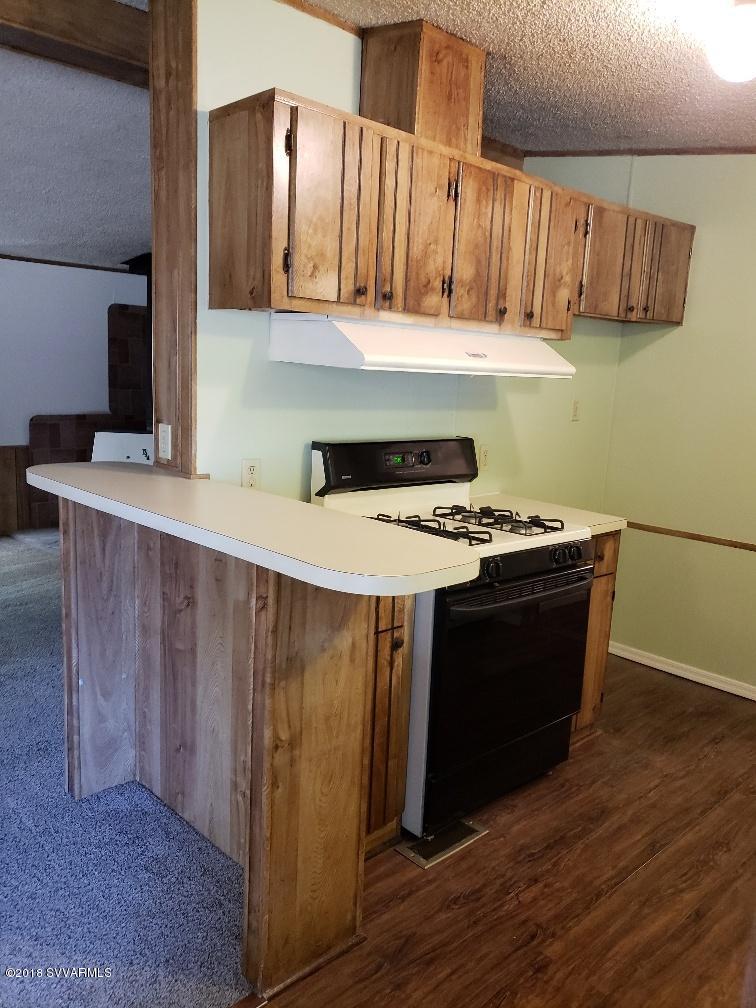 4330 East Waldron Road Rimrock, AZ 86335 - Photo 12 of 43 a kitchen with stainless steel appliances hardwood floor sink stove and wooden cabinets