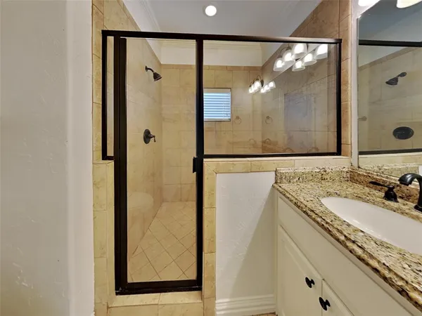 a bathroom with a shower sink and mirror