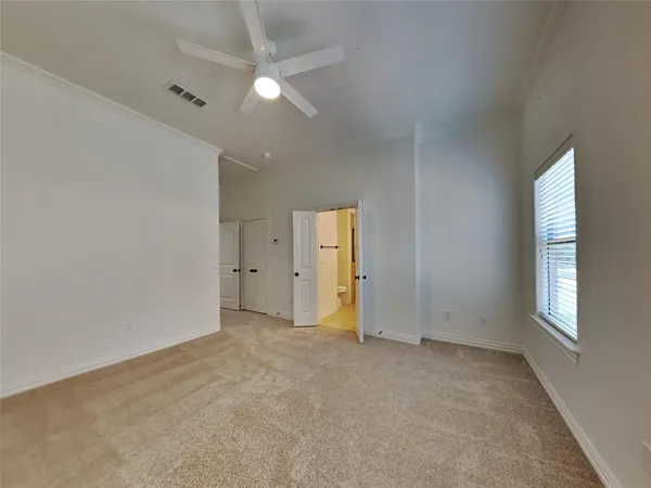 an empty room with a window and a ceiling fan