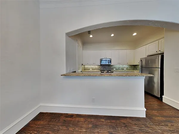 a view of kitchen with stainless steel appliances granite countertop cabinets and wooden floor