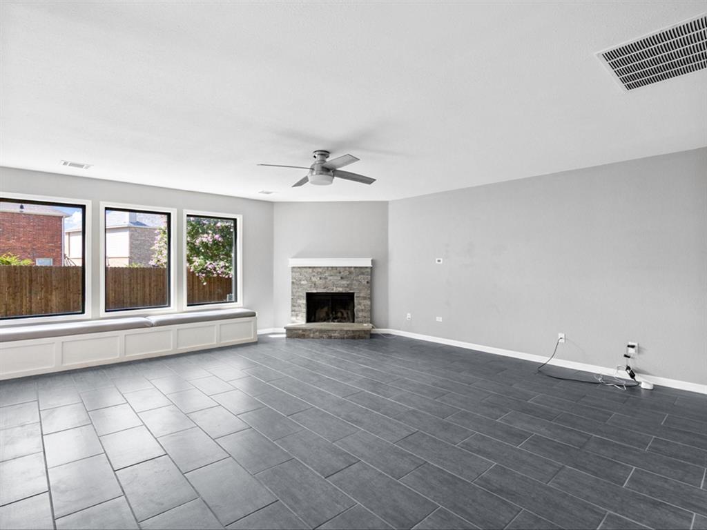 5304 Los Altos Road Fort Worth, TX 76244 - Photo 6 of 30 Unfurnished living room with ceiling fan and a stone fireplace