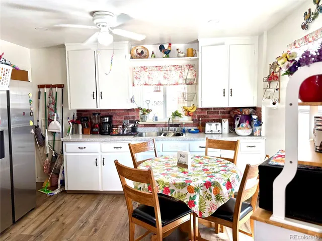 a view of kitchen with stainless steel appliances granite countertop dining table and chairs