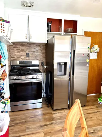 a kitchen with stainless steel appliances and wooden floor