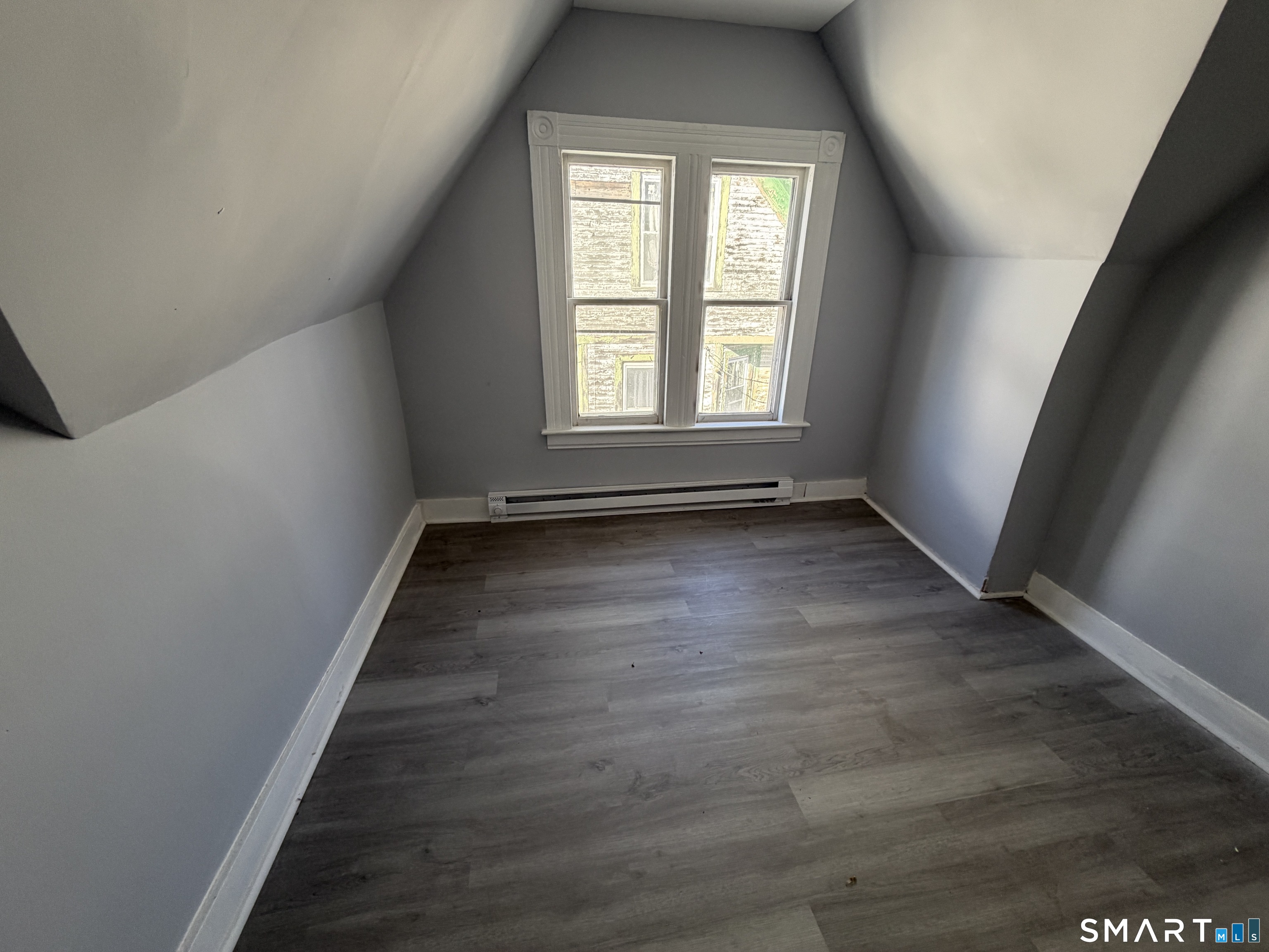 73 Waterville Street, Unit 3 Waterbury, CT 06710 - Photo 9 of 9 an empty room with wooden floor and windows
