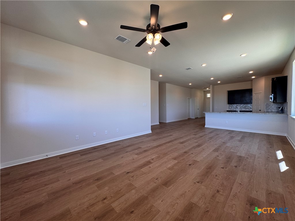 310 University Avenue Troy, TX 76579 - Photo 12 of 21 an empty room with wooden floor and a ceiling fan