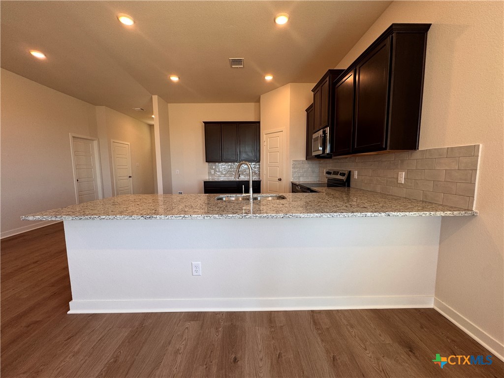 310 University Avenue Troy, TX 76579 - Photo 13 of 21 a large kitchen with kitchen island a sink and a stove top oven