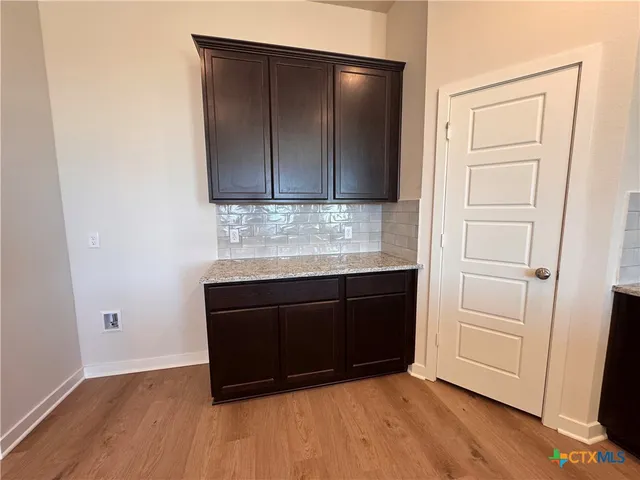 a room with a wooden floor and cabinets