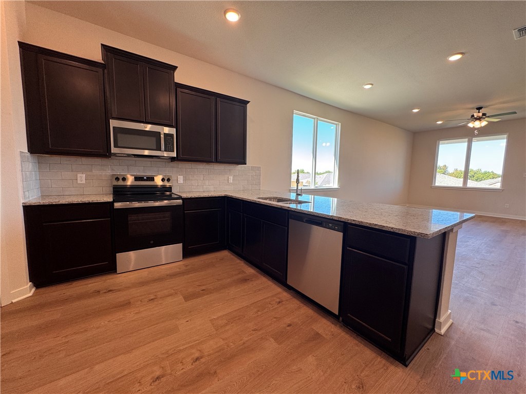 310 University Avenue Troy, TX 76579 - Photo 9 of 21 a kitchen with a sink and wooden cabinets