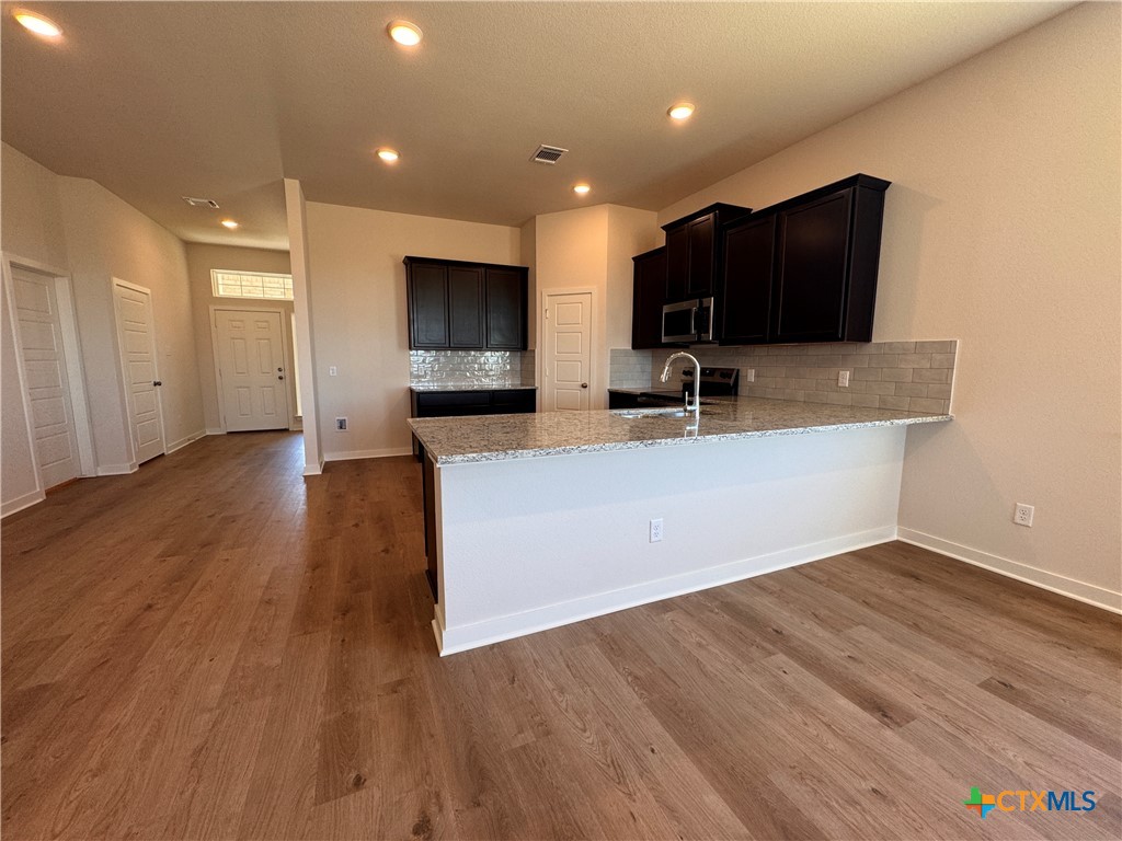 310 University Avenue Troy, TX 76579 - Photo 10 of 21 a living room with stainless steel appliances wooden floor large screen and a kitchen view