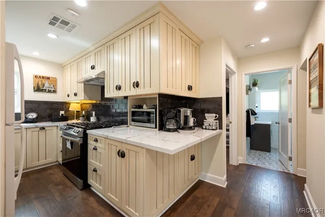 a kitchen with stainless steel appliances granite countertop a stove a sink and a refrigerator