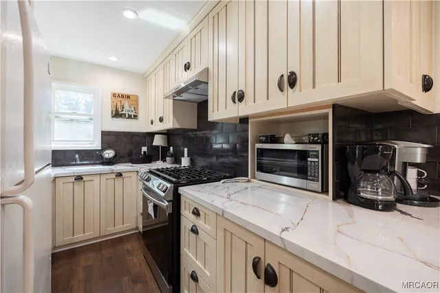 a kitchen with stainless steel appliances granite countertop a stove and a sink
