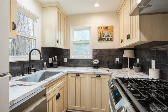 a kitchen with granite countertop a sink stove and cabinets