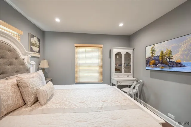 a bedroom with a large bed and a window