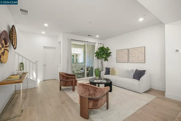 a dining room with kitchen island stainless steel appliances furniture a large window and kitchen view