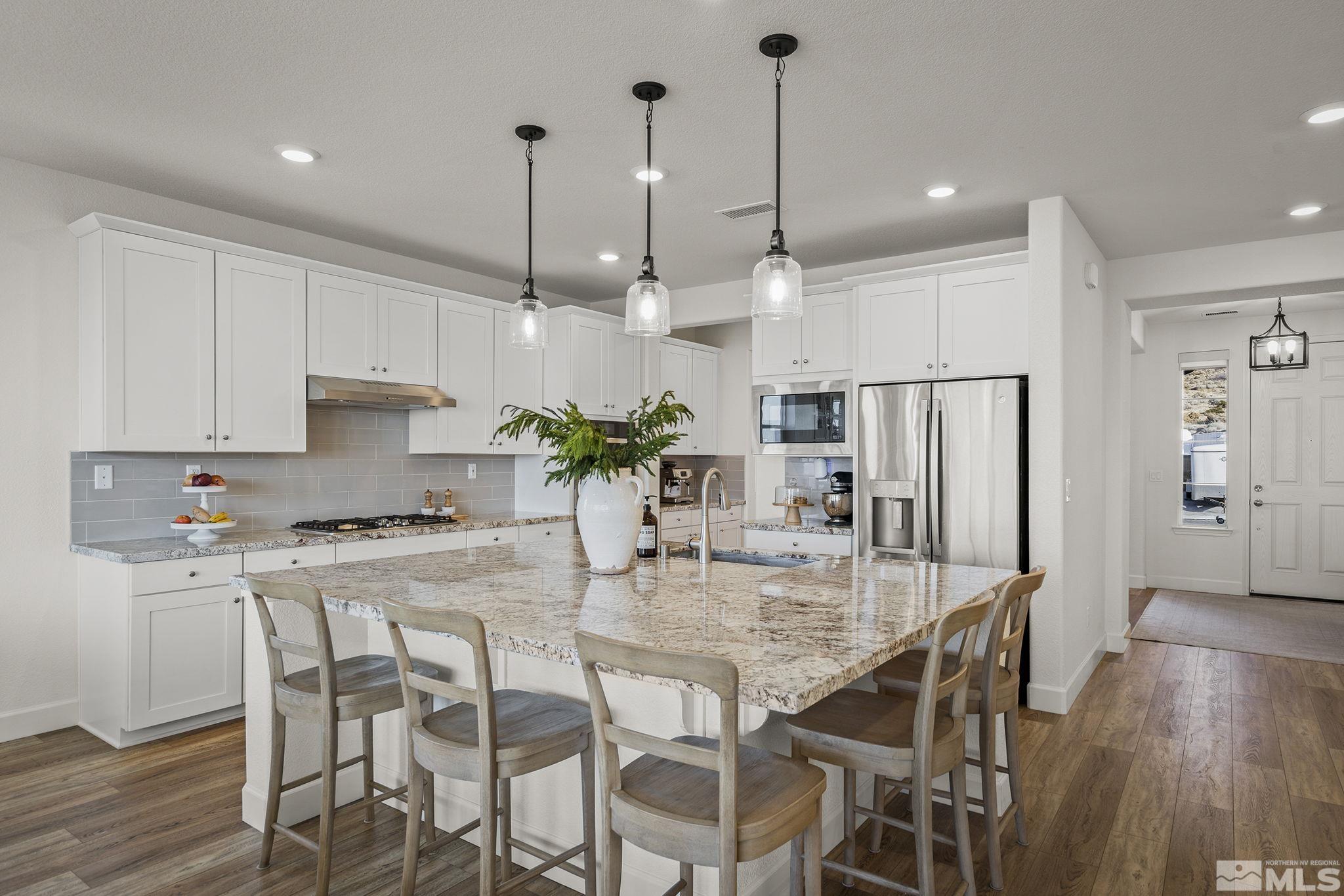 10489 Claim Jumper Way Reno, NV 89521 - Photo 14 of 40 a kitchen with kitchen island a refrigerator and wooden floor