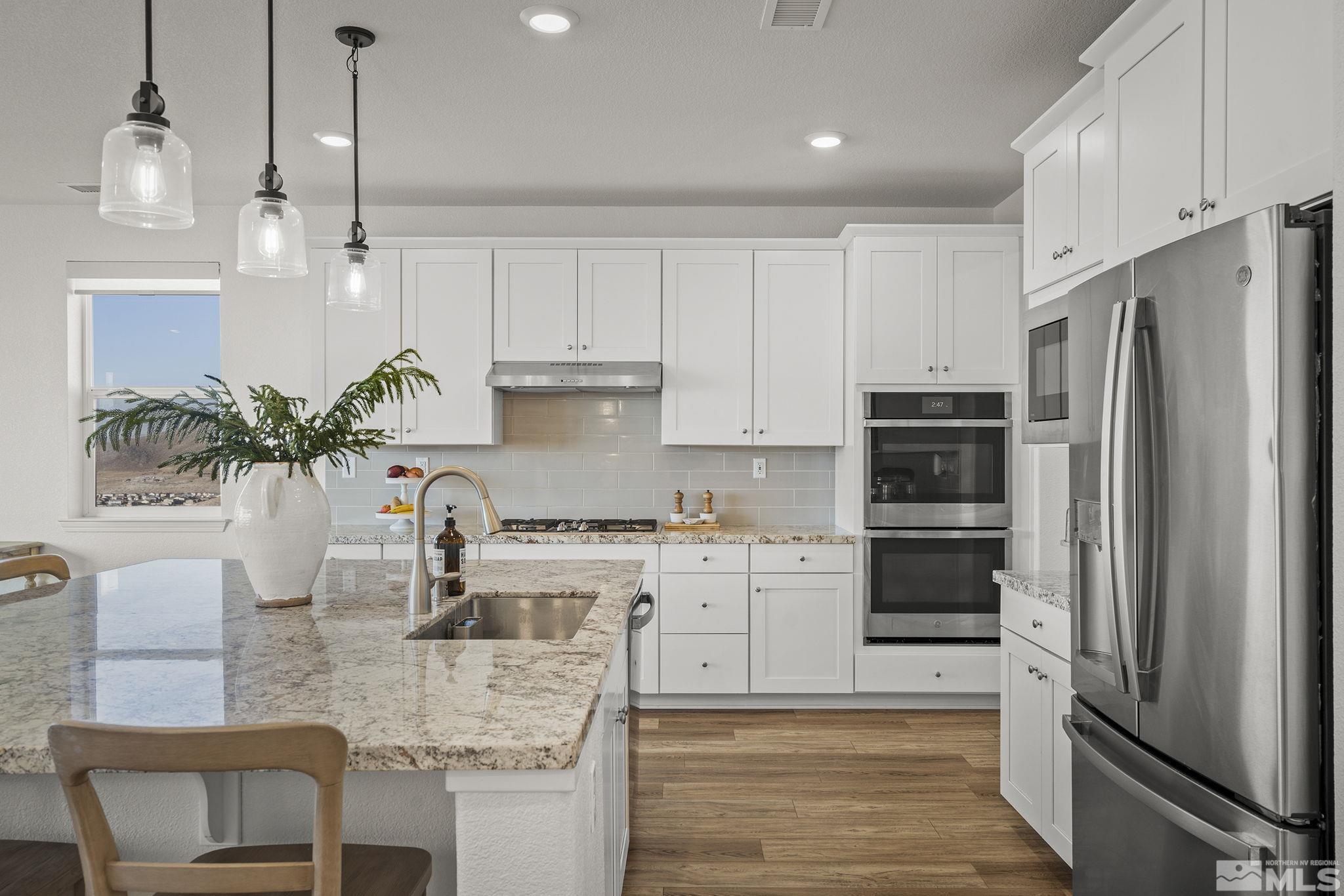 10489 Claim Jumper Way Reno, NV 89521 - Photo 15 of 40 a kitchen with white cabinets and stainless steel appliances