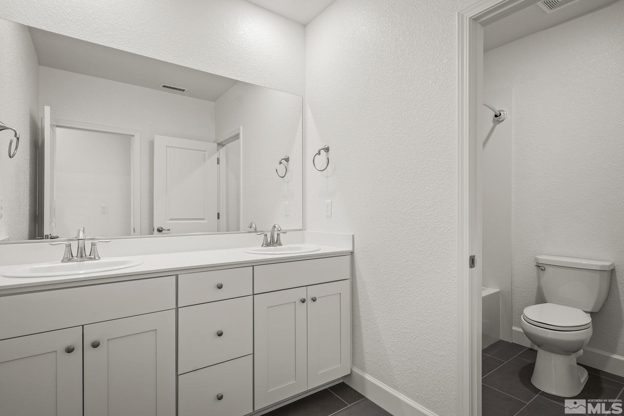 10489 Claim Jumper Way Reno, NV 89521 - Photo 25 of 40 a bathroom with a toilet sink and mirror