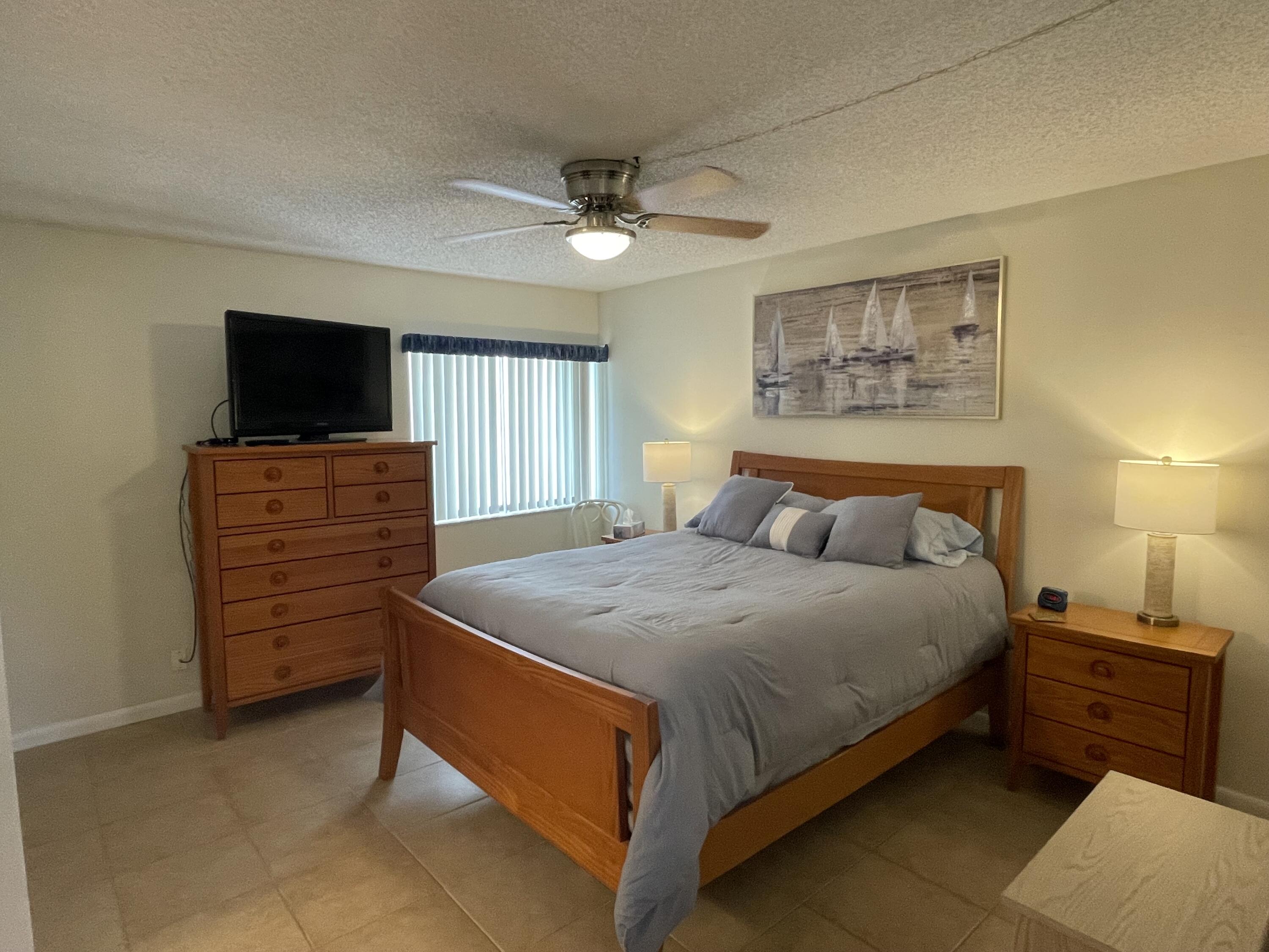1605 Highway 1, Unit 201V2 Jupiter, FL 33477 - Photo 3 of 9 a bedroom with a bed and a television