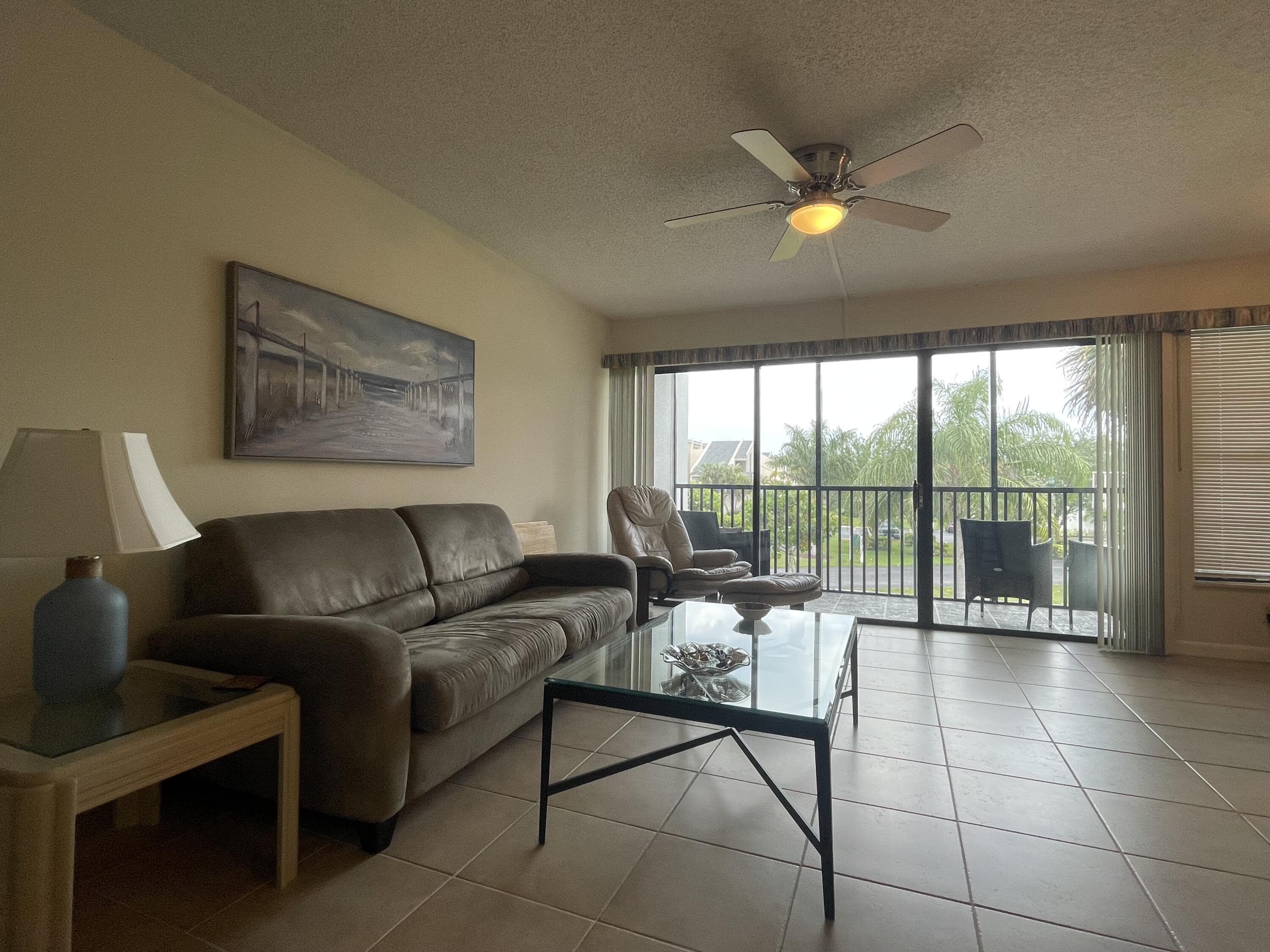 1605 Highway 1, Unit 201V2 Jupiter, FL 33477 - Photo 7 of 9 a living room with furniture and a floor to ceiling window