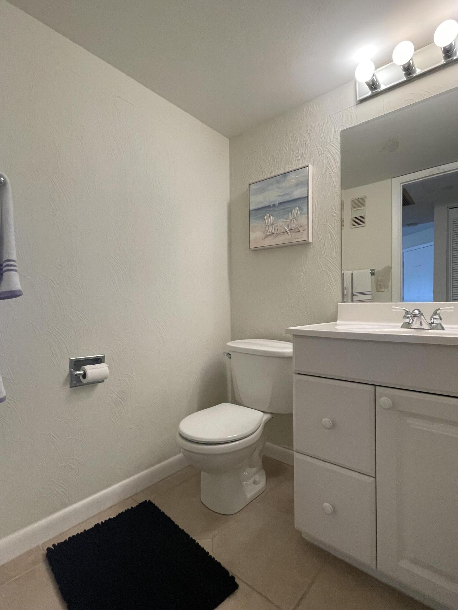 1605 Highway 1, Unit 201V2 Jupiter, FL 33477 - Photo 9 of 9 a bathroom with a sink a toilet a mirror and shower